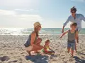 Rodzina cieszy się wakacjami, gdzie nad morze z dzieckiem. Słońce, piasek i zabawa na plaży.