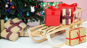 Choinka, prezenty i sanie na jasnym tle.